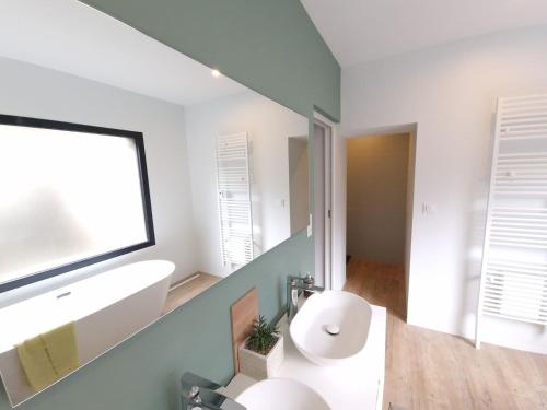 a bathroom with a white sink and a window at Spacieux au cœur de Pont-Aven Au Bois d'Amour 1-6p in Pont-Aven