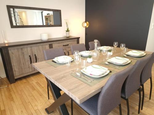 - une table à manger avec des chaises et un miroir dans l'établissement Spacieux au cœur de Pont-Aven Au Bois d'Amour 1-6p, à Pont-Aven