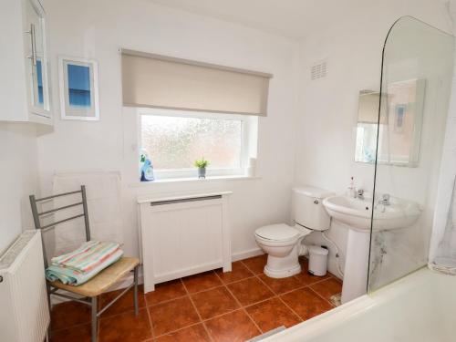 a bathroom with a toilet and a sink and a window at The Hawthorns in Chester