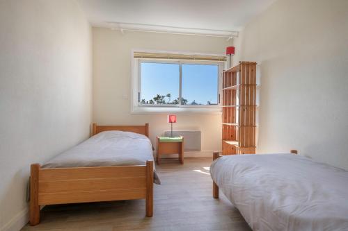 een slaapkamer met 2 bedden en een raam bij Face au port, appartement pour 4 personnes in Le Pouliguen