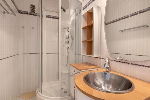 een badkamer met een wastafel en een douche bij Face au port, appartement pour 4 personnes in Le Pouliguen