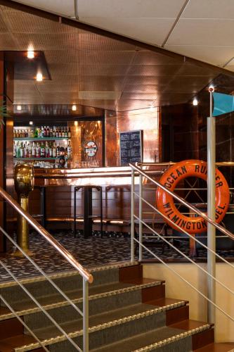 un bar avec des escaliers et un panneau sur le mur dans l'établissement Hôtel Oceania Brest, à Brest