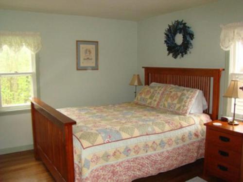 a bedroom with a bed and a wreath on the wall at Lynns Cottage at Heron Ledge in Plattsburgh