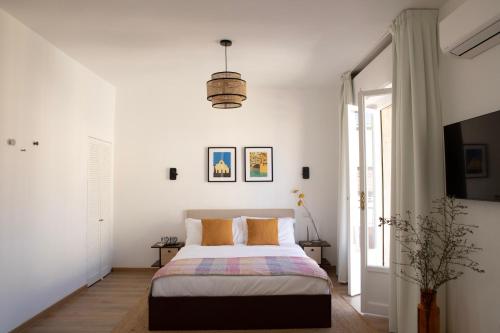 a white bedroom with a bed and a window at Bob W Ponte Vecchio in Florence