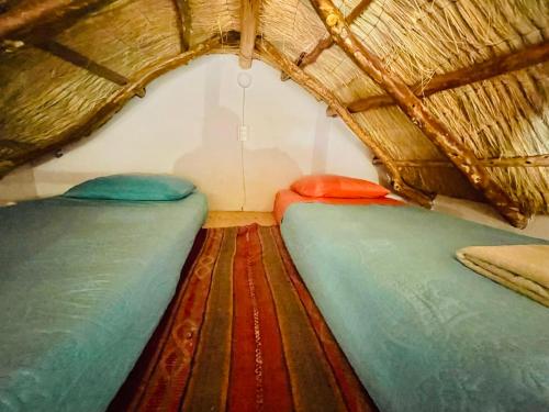 a room with two beds in a wicker tent at Cabañas Turi Lackar in San Pedro de Atacama
