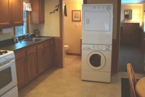 a kitchen with a washing machine and a sink at Pine Cottage at Heron Ledge in Plattsburgh