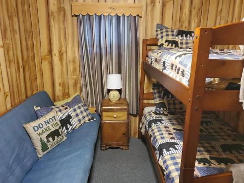 a bedroom with two bunk beds and a couch at Augur Lake Cabin Escape in Au Sable Forks