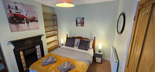 a bedroom with a bed with two towels on it at Beautiful Spacious 5 Bed House in Fornham Saint Martin