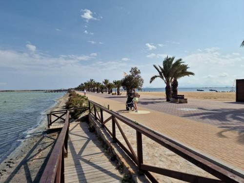 eine Person, die am Strand entlang einer Promenade geht in der Unterkunft La Casa Costera Càlida in San Pedro del Pinatar