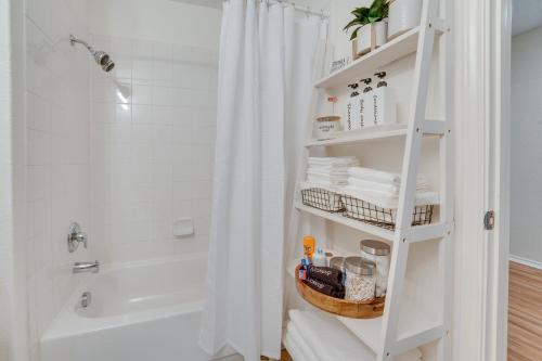 uma casa de banho com uma cortina de chuveiro e uma prateleira branca em Sunny Universal City Home about 18 Mi to San Antonio! em San Antonio