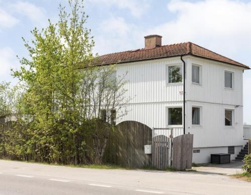 a white house on the side of the street at Comfortable guest rooms with fully equipped kitchen and cosy living room. in Ödsmål