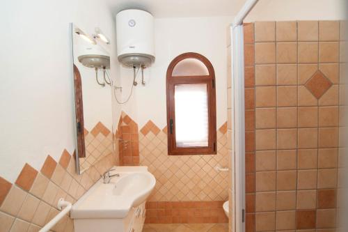 uma casa de banho com um lavatório e um espelho em Appartamenti Sant'Anna em Budoni