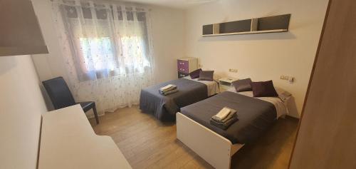 Habitación pequeña con 2 camas y silla en Oasis Inn Pedornes en Pedornes