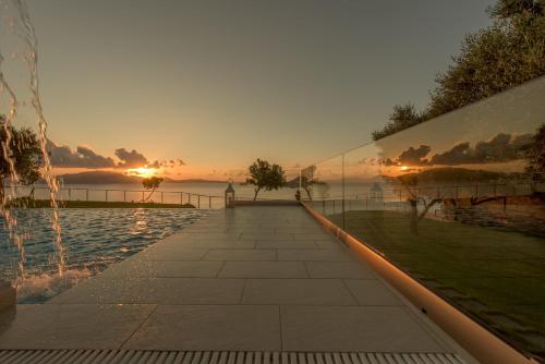 a view of a pool with the sunset in the background at Avra Luxury Villa & Spa in Keri