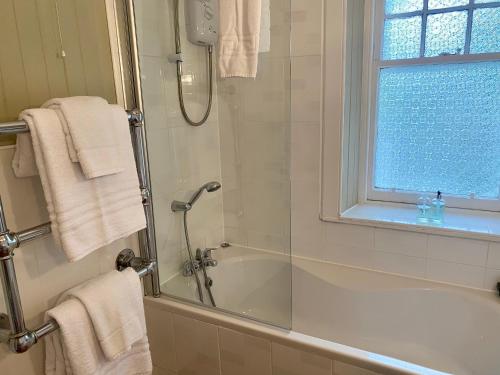 bagno con doccia, vasca e finestra di Ards House a Oban