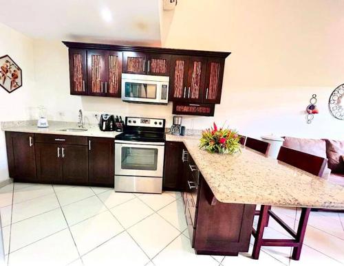 a kitchen with wooden cabinets and a counter top at Cabo Velas 19 Jungle Paradise in Santa Cruz