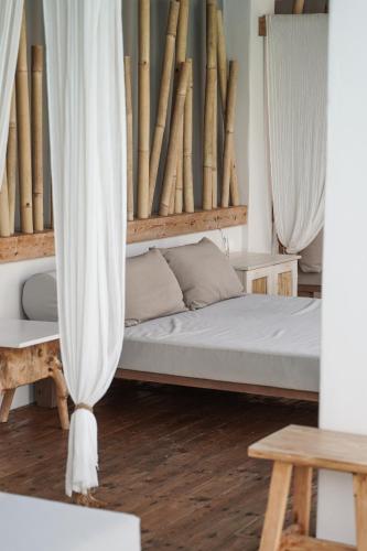 a bedroom with a bed with white curtains at Crystal Waters in Nikiana