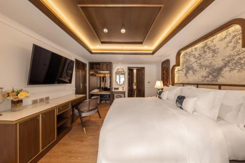 a bedroom with a bed and a desk with a television at CHINO@NIMMAN Luxury Boutique Hotel in Chiang Mai