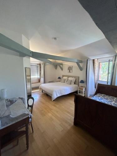 a large bedroom with a bed and a couch at Chambres d'hôtes Maison Redon in Tour-de-Faure