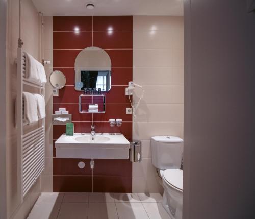 a bathroom with a sink and a toilet at Grand Hotel en Résidence De Draak in Bergen op Zoom