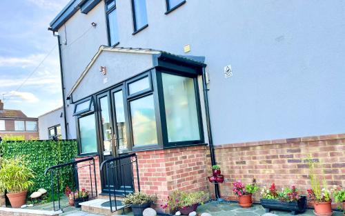 a house with a black door and some potted plants at Ar-Rahman, 1 bed room and 1 Living room apartment in Kent
