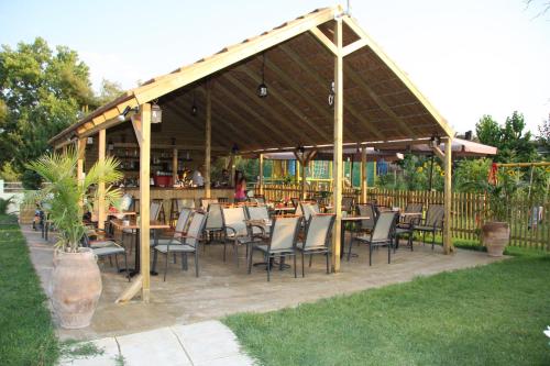a restaurant with tables and chairs under a pavilion at Olympion Village Studios in Zakharo