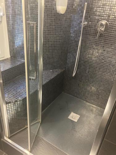 a bathroom with a shower with a glass door at Brignole Rooms in Genova