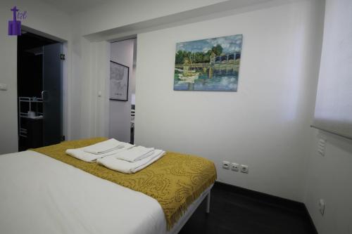 1 dormitorio con 1 cama con 2 toallas en Lisbon North Apartment, en Lisboa