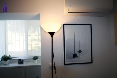a lamp in a room with a picture on the wall at Lisbon North Apartment in Lisbon