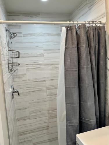 a bathroom with a shower with a shower curtain at Close to everything! Perfect basecamp for WPB in West Palm Beach