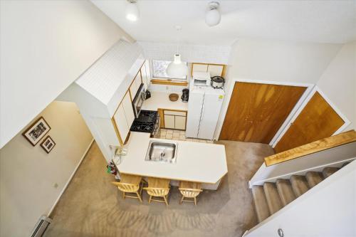 an overhead view of a kitchen with a table and chairs at Just a stone's throw from the heart of town, this 2 bedrooms unit features a whirlpool tub, fireplace and sport center in Killington