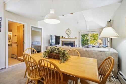 a dining room and living room with a table and chairs at Woods V17 2-Bed & Loft with Fireplace, whirlpool tub, and sports center in Killington