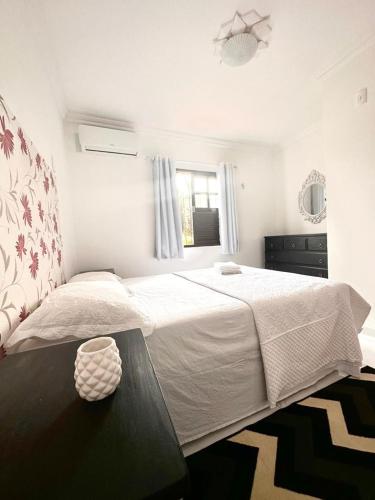 a bedroom with a large white bed and a table at Luxury Duplex Casa in Natal