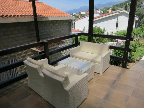 a balcony with white chairs and a table at Reževići Apartments in Petrovac na Moru