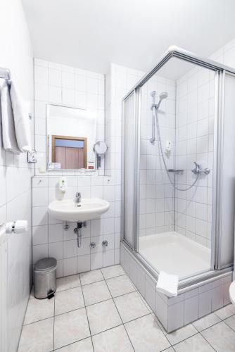 a bathroom with a shower and a sink at Hotel Lüttje Burg in Lütjenburg