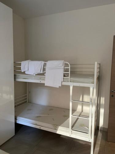 ローマにあるSan Pietro houseの白い二段ベッド(タオル付)が備わる客室です。