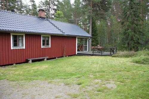 a red house with a bench in front of it at Fängen in Vaggeryd
