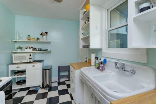 a kitchen with a sink and a checkered floor at Charming 1BR Vintage Treehouse Garage Apartment in Orlando