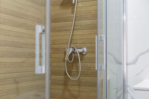 una doccia con tubo fissato a una porta di vetro di Precioso loft El Arcángel junto a la Ribera a Cordoba