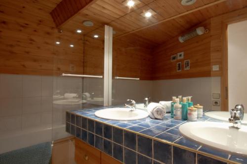 a bathroom with two sinks and a shower at Tignes Le Lac - Appartement au pied des pistes (6 personnes) in Tignes