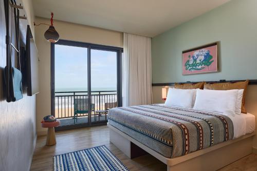 a bedroom with a bed and a large window at Moxy Virginia Beach Oceanfront in Virginia Beach
