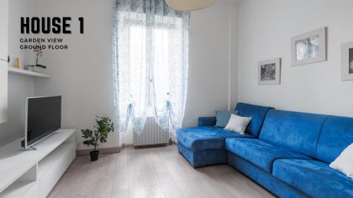 ein Wohnzimmer mit einem blauen Sofa und einem TV in der Unterkunft CASA VACANZE ANNA in Bergamo