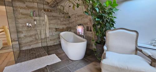 a bathroom with a tub and a glass shower at Locagites82 in Moissac