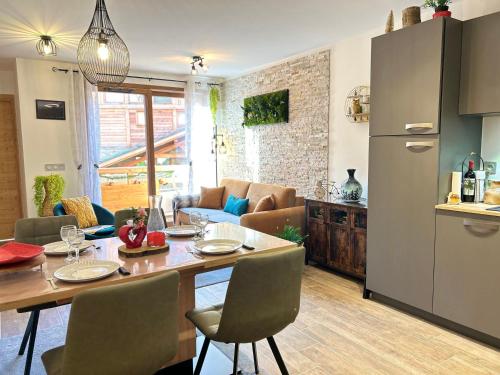 une cuisine et un salon avec une table et des chaises dans l'établissement Moderne appartement 4 pers avec balcon sud, parking et WiFi - à 200m des pistes et navette - FR-1-623-255, aux Gets