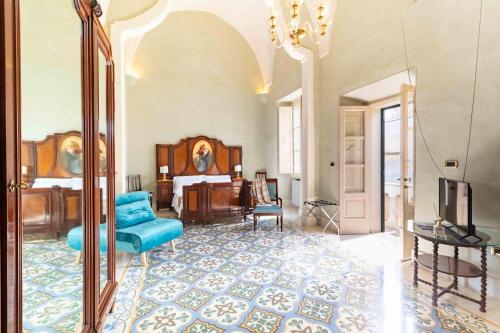 a living room with a blue couch and a television at Palazzo Zacà in Gallipoli