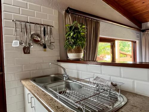 a kitchen sink with a dish drying rack next to it at San Lameer Villa 2112 in Southbroom