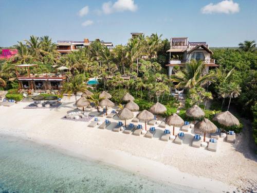 an aerial view of a resort with chairs and umbrellas on the beach at Jashita Hotel in Tulum