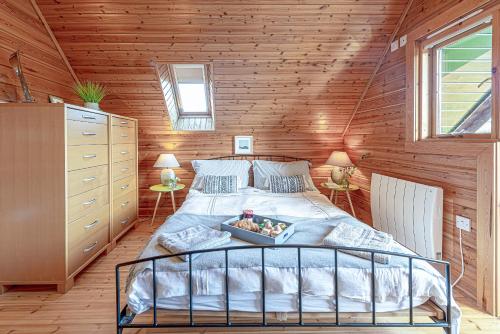 a bedroom with a bed with a tray of food on it at Scandi Cabin in Heart of Anglesey with Parking in Llanfairpwllgwyngyll