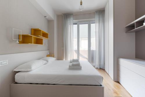 een slaapkamer met een bed en een groot raam bij GuestHost - Bullona Bright & Design Apt - M5 Gerusalemme in Milaan