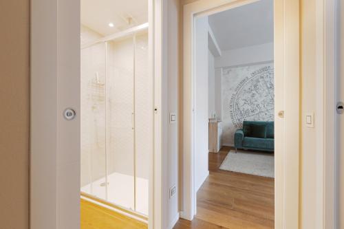 een kamer met een glazen deur en een blauwe bank bij GuestHost - Bullona Bright & Design Apt - M5 Gerusalemme in Milaan